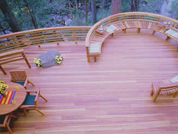 B Grade redwood decking and a beautiful, curved railing with built-in bench makes a perfect outdoor space.